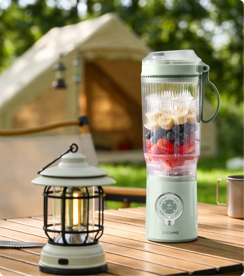Batidora Dreame Portable Blender batiendo fruta fresca al aire libre para disfrutar en el camping